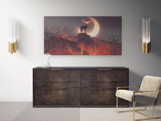 Tableau sur toile d'un cerf sur un rocher devant un croissant de lune, accroché au-dessus d'un buffet avec des lampes dorées.
