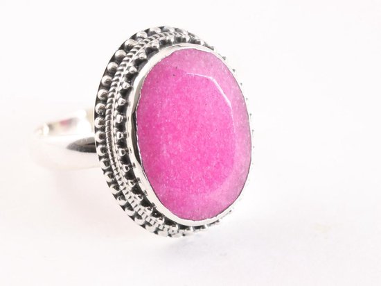 Bewerkt zilveren ring met een ovale, felroze steen met facetten. De ringband heeft een decoratief, bewerkt patroon.