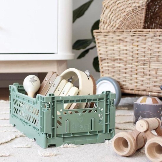 Kaki Aykasa Midi opbergkrat gevuld met houten speelgoed, inclusief xylofoon en maracas.