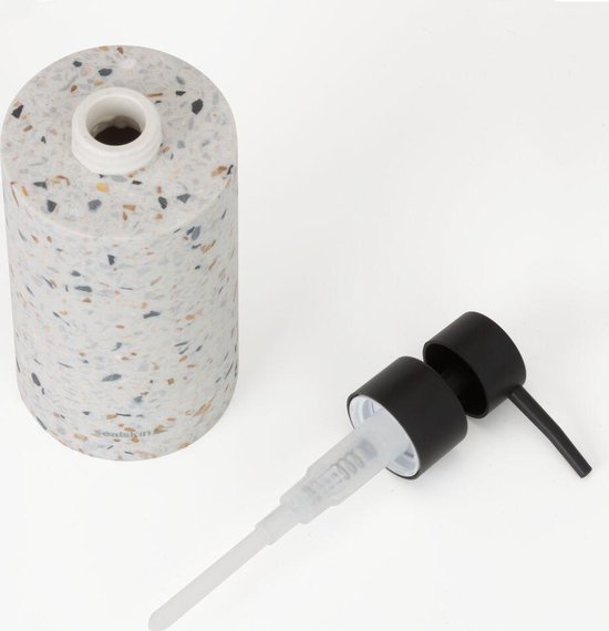 Zeepdispenser met terrazzo-look, losse zwarte pompdop ernaast.