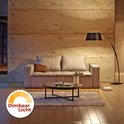 Woonkamer met bank en zwarte booglamp, met een indicator voor dimbaar licht.