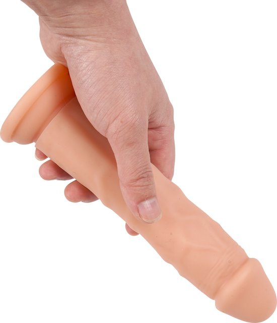 Hand die een beige dildo met textuur en platte basis vasthoudt.