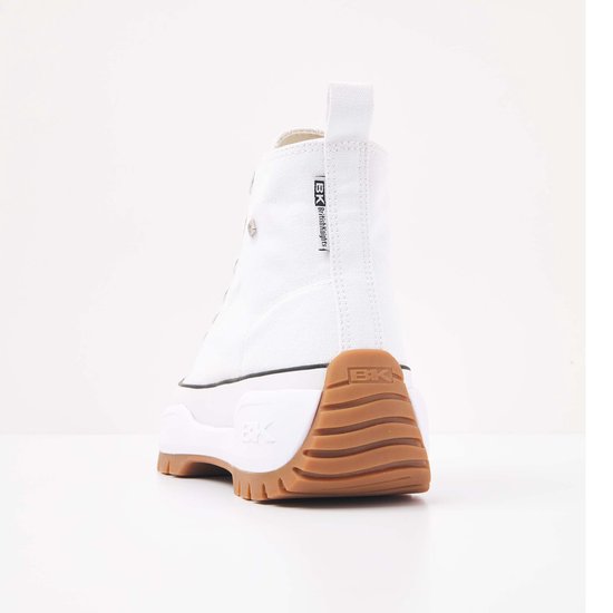 Achterkant van een witte canvas hoge sneaker met bruine profielzool en 'BK' logo op zoolrand.
