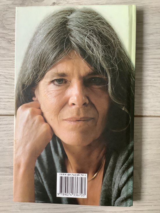 Portret van een vrouw met grijs haar, leunend op haar hand.