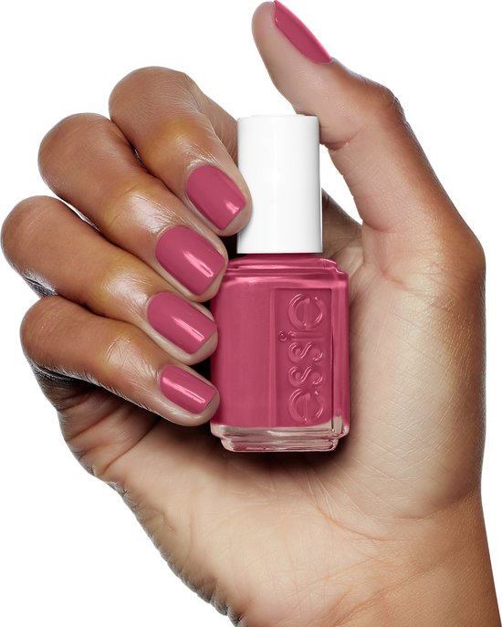 Hand met medium huidskleur die een flesje Essie nagellak vasthoudt. Nagels gelakt in de kleur roze.
