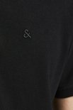 Detail van de linkerborst van een zwarte polo met een geborduurd donker logo.