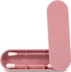 Roze opbergdoosje, open, met twee herbruikbare wattenstaafjes erin. Een met een witte punt, de ander met een borsteltje.