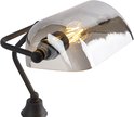 Gros plan de l'abat-jour en verre gris et du bras métallique d'une lampe de banquier.