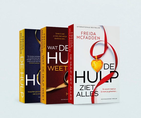 Drie boeken op een rij: "DE HULP", "WAT DE HULP WEET", "DE HULP ZIET ALLES". De middelste toont een hart-hanger.