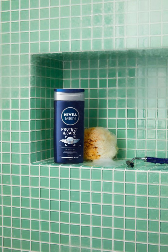 NIVEA MEN Protect & Care douchegel fles naast een scheermesje en een spons met schuim, tegen een groene tegelmuur.