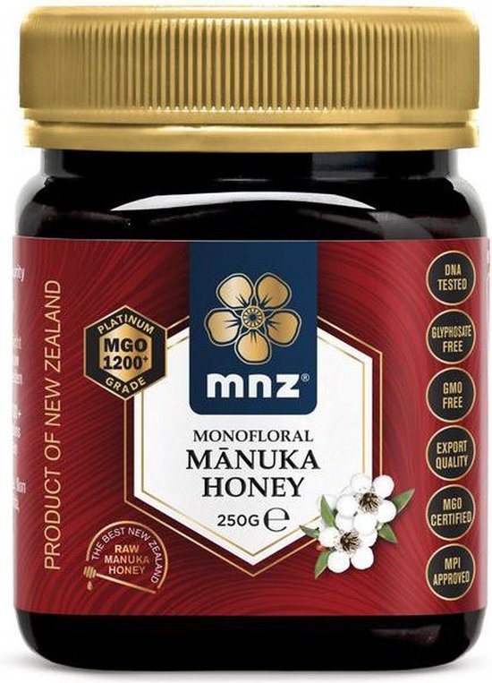 Pot Manuka honing met goudkleurige deksel, rood etiket met gouden bloemen en diverse keurmerken.