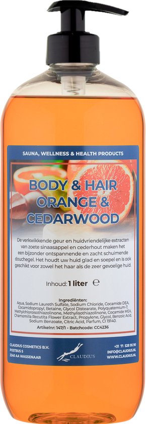 Doorzichtige fles met oranje douchegel, zwart pompje, en een label met 'BODY & HAIR ORANGE & CEDARWOOD'.