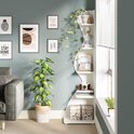 Wit, golvend hoekrek met 5 niveaus, versierd met planten, kunstobjecten, een kalender en decoratieve dozen.