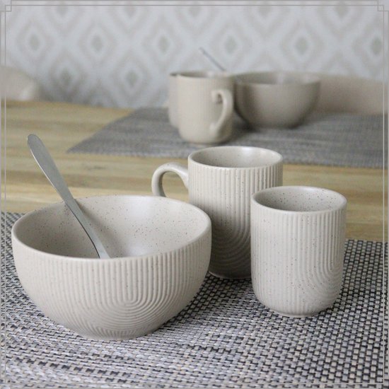Mise en place de table avec des tasses et un bol blanc cassé à motif côtelé.