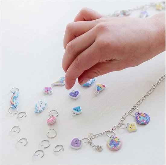 Kinderhandjes kiezen bedels voor een armband, met een ketting en losse bedels.