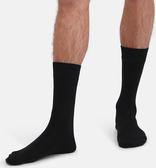 Mannenbenen met zwarte sokken tot halverwege de kuit.