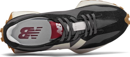 Bovenaanzicht van een zwarte New Balance sneaker met grijs, beige en witte details. New Balance logo op binnenzool.