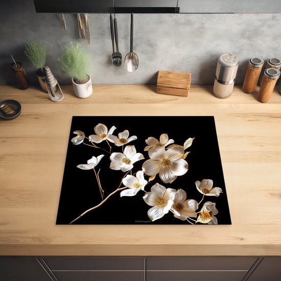 Glazen snijplank met witte en gouden bloemen op een zwarte achtergrond.