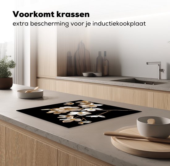 Glazen snijplank met witte en gouden bloemen, op een aanrecht.