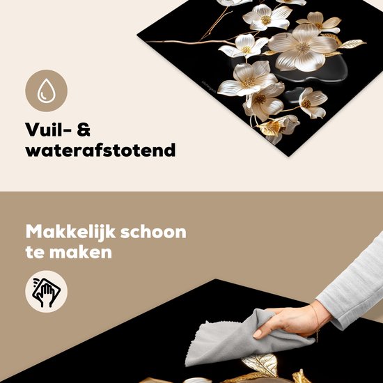 Detail van de snijplank met witte en gouden bloemen, en een hand die hem schoonmaakt.