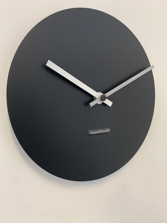 Horloge rond noir avec aiguilles argentées et logo 'ChantalBrando'.