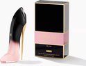 Zwarte parfumdoos met roze band en 'Good Girl Blush Elixir' tekst, naast een stiletto parfumfles in zwart en roze met gouden hak.