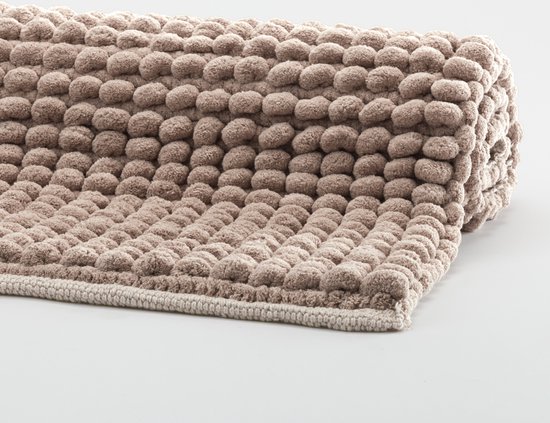 Een opgerolde badmat in de kleur taupe met een gedetailleerd bobbelig patroon en een beige rand.