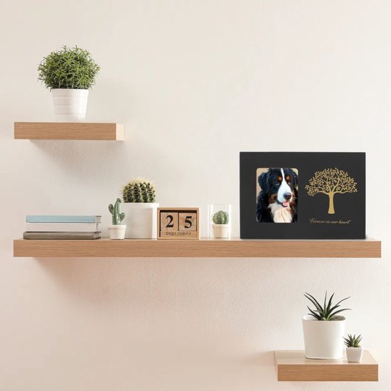 Zwarte urn met gouden boomdecoratie, 'Forever in our heart' en foto van een Berner Sennen hond op een dressoir.
