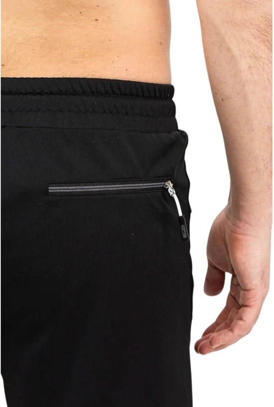 Close-up van de tailleband en het ritsvak van een zwarte korte sportbroek.