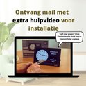 Laptop scherm toont installatievideo voor OER dementieklok, met een hand die een afstandsbediening vasthoudt.