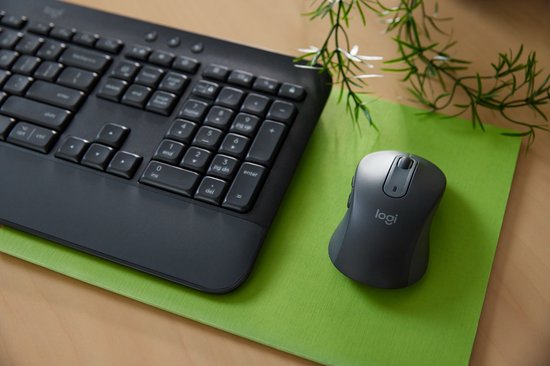 Donkergrijs Logitech toetsenbord en muis op een felgroene onderlegger.