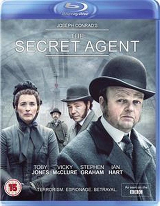 Blu-ray hoes van 'The Secret Agent' met vier personen in klederdracht uit de 19e eeuw. Toby Jones op de voorgrond.