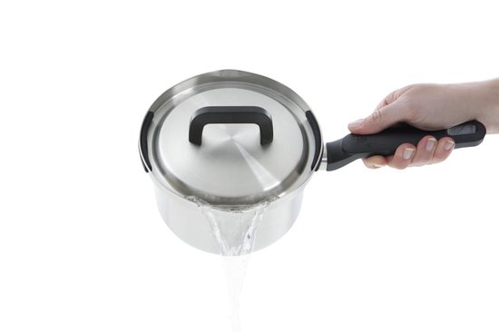 Hand die roestvrijstalen pan met gesloten deksel vasthoudt terwijl water wordt afgegoten.