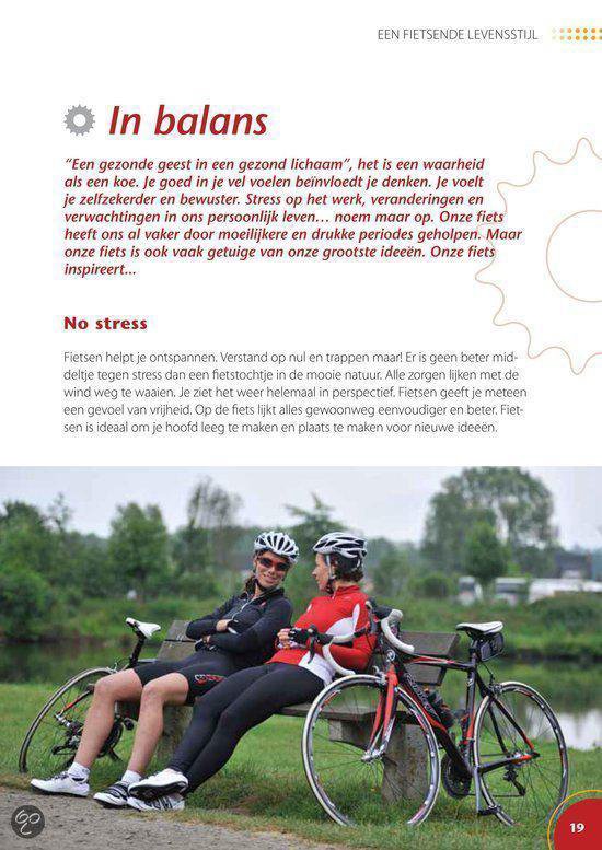 Twee vrouwen in fietskleding zitten op een bankje naast hun racefietsen in een park.