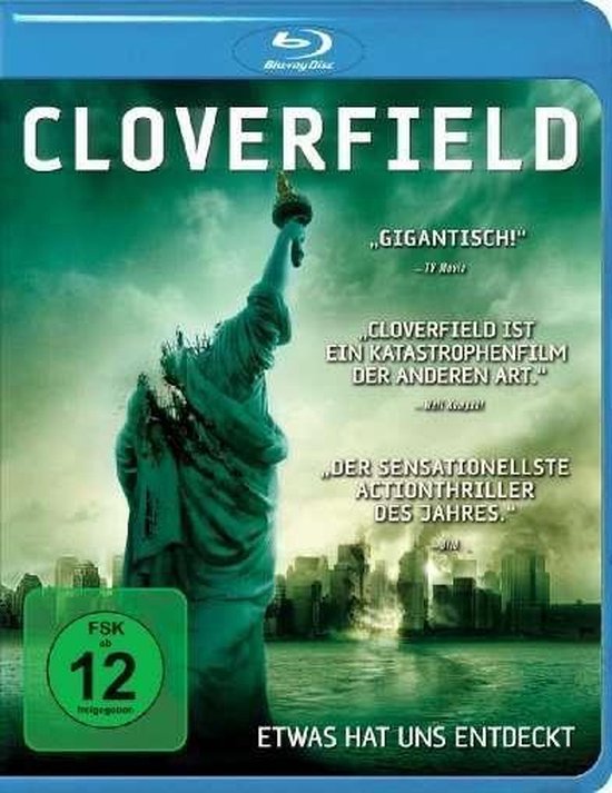Blu-ray hoes voor Cloverfield. De Statue of Liberty is beschadigd met een groene, mistige achtergrond van een stad.