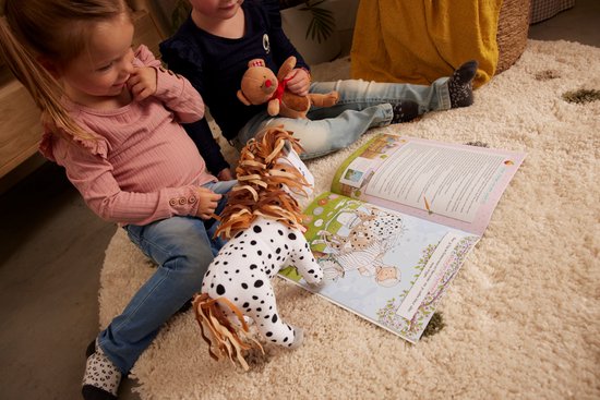 Twee kinderen lezen een open doeboek met een illustratie van een pony. Een knuffelpony ligt op het kleed.