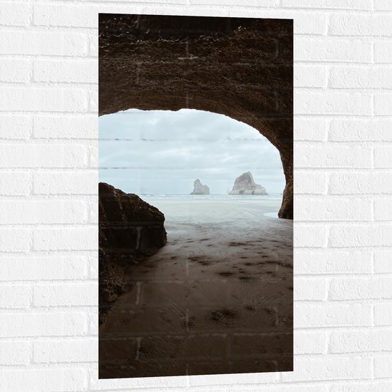 WallClassics - Muursticker - Uitzicht op Mist boven Zee vanuit Grot - 50x100 cm Foto op Muursticker