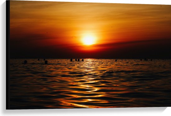 WallClassics - Canvas  - Zwemmende Mensen in Zee bij Ondergaande Zon - 90x60 cm Foto op Canvas Schilderij (Wanddecoratie op Canvas)