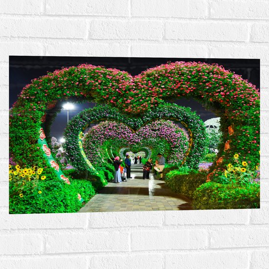 WallClassics - Muursticker - Hartvormige Bloemenbogen in Park - 75x50 cm Foto op Muursticker