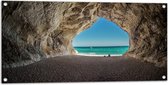 WallClassics - Tuinposter – Strand in een Grot aan Zee - 100x50 cm Foto op Tuinposter  (wanddecoratie voor buiten en binnen)