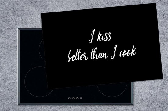 Zwarte kookplaatbeschermer met witte tekst "I kiss better than I cook", op een inductiekookplaat.