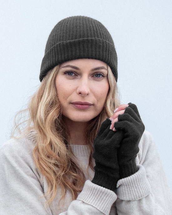 Donkergrijze gebreide muts en vingerloze handschoenen op een blonde vrouw met blauwe ogen.