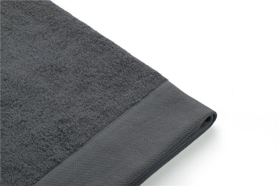 Gros plan du bord tissé d'une serviette gris foncé.