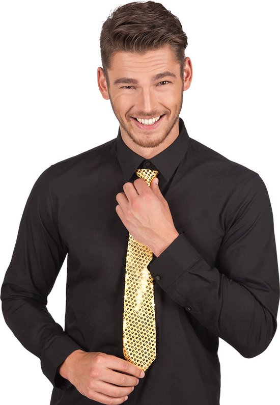 Man met kort bruin haar, grijze baard, zwart overhemd en gouden glitterstropdas die hij aanraakt.