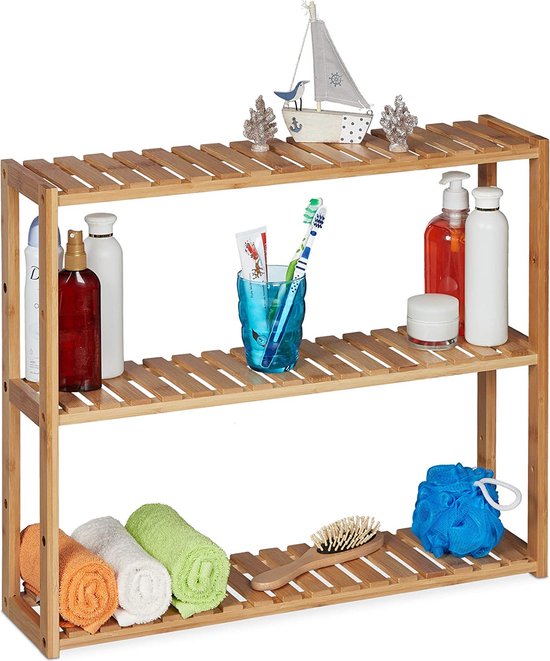 Drie-laags bamboe rek met diverse badkamerartikelen zoals zeep, tandenborstels, handdoeken en een decoratieve boot.
