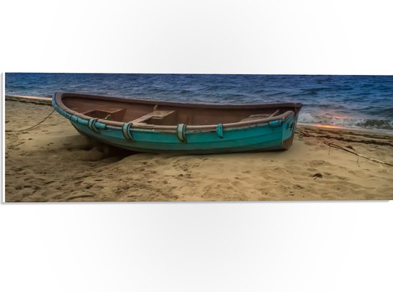 WallClassics - PVC Schuimplaat- Blauwe Schippersboot op het Strand met Ondergaande Zon - 60x20 cm Foto op PVC Schuimplaat