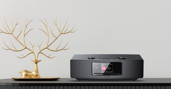 Zwart Kenwood radio-apparaat naast een gouden hertenornament.