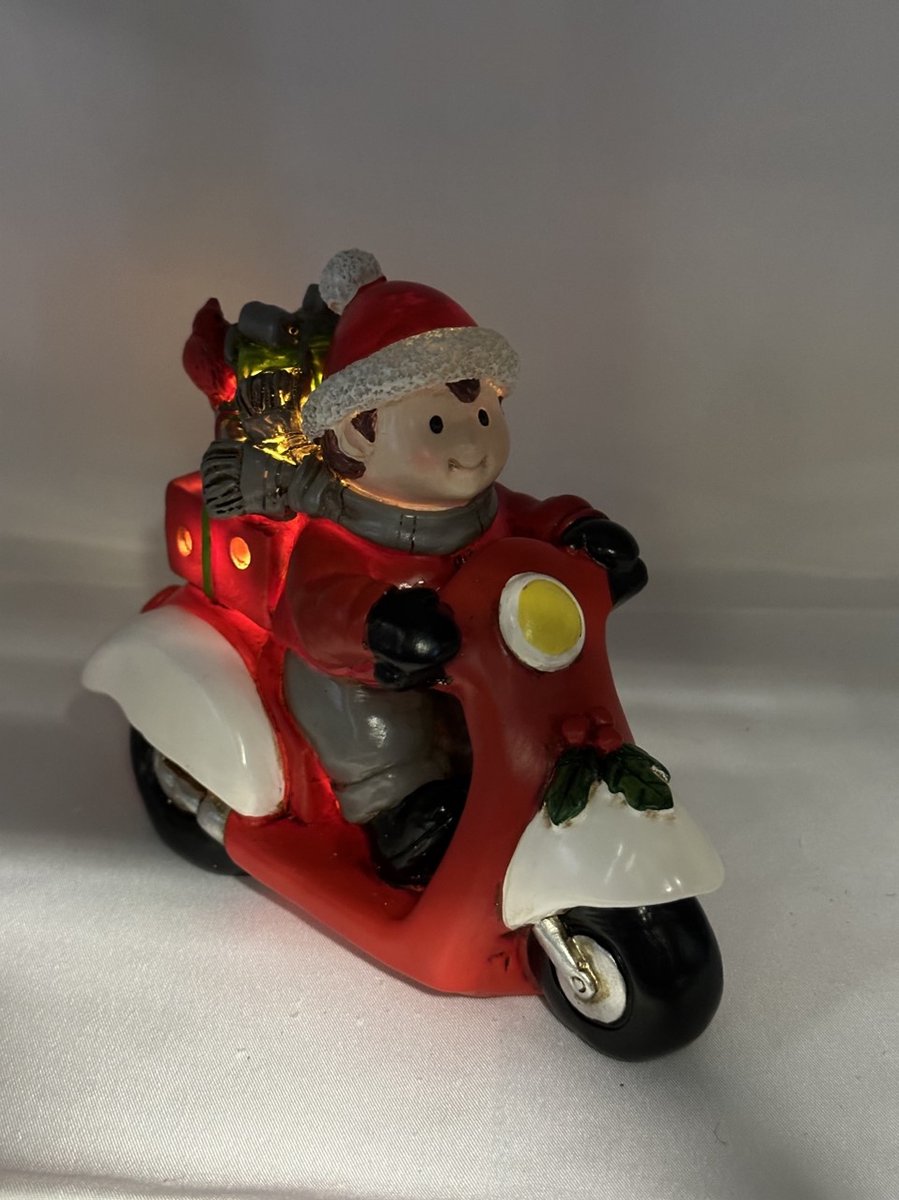 Kerstbeeldje jongen op rode scooter met LED - rood + grijs + groen cadeau - polyresin - 12 cm hoog x 16 cm x 8 cm – Kerstdecoratie
