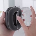 Handen die een donkergrijze AirPods Max met een doorzichtige hoes monteren.