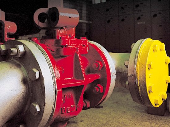 Industriële machine met rode en gele afwerking en metalen leidingen.